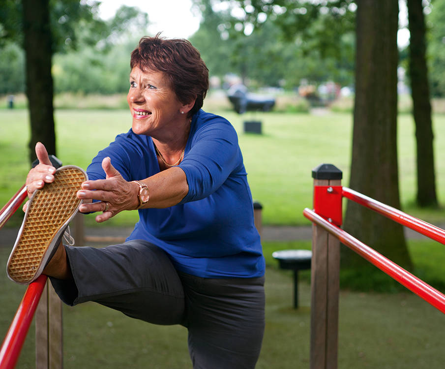 Donna attiva che fa esercizi di stretching nel parco